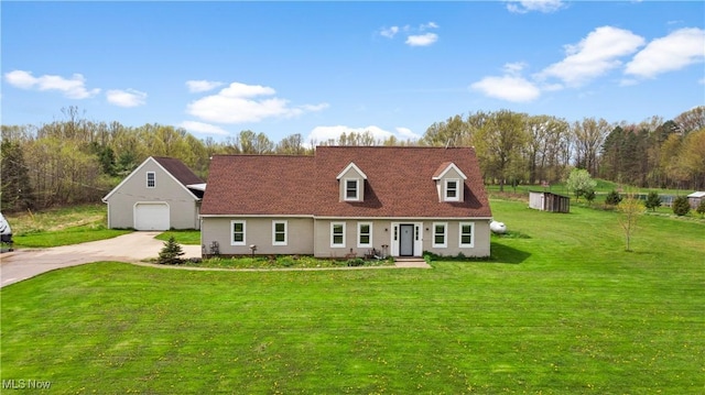 view of front of property featuring a front yard, an outbuilding, a detached garage, and concrete driveway
