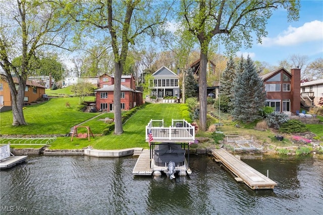 dock area with stairs, a water view, and a yard