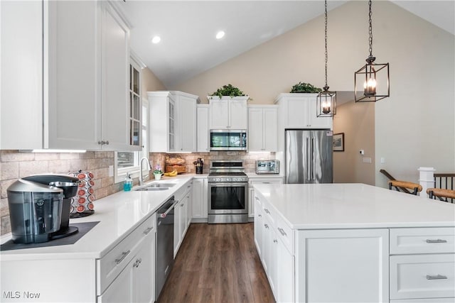 kitchen featuring decorative backsplash, a kitchen island, dark wood-style flooring, a sink, and stainless steel appliances