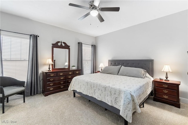 bedroom with a ceiling fan and light carpet