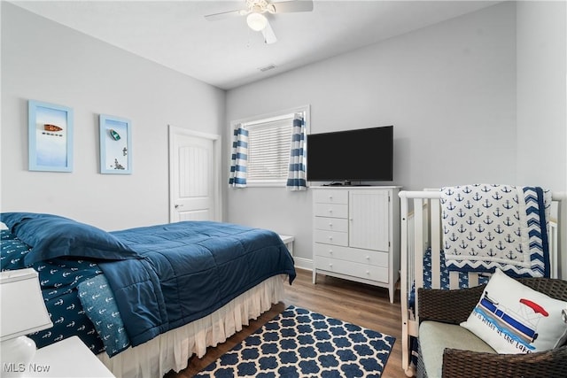 bedroom with a ceiling fan, wood finished floors, and visible vents