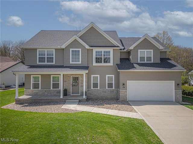 craftsman inspired home with covered porch, concrete driveway, a front yard, and stone siding