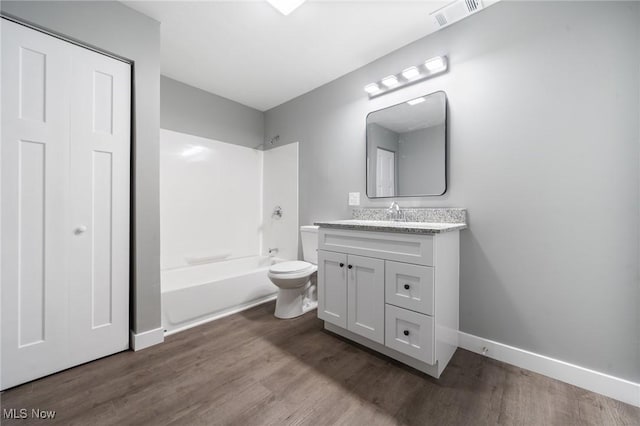 bathroom with bathtub / shower combination, vanity, toilet, wood finished floors, and visible vents