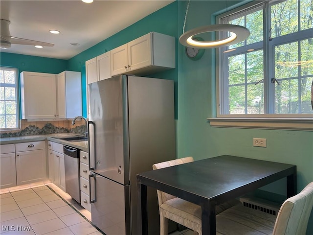 kitchen featuring a sink, light tile patterned floors, white cabinets, stainless steel appliances, and recessed lighting