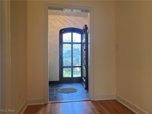 entryway featuring baseboards and hardwood / wood-style floors