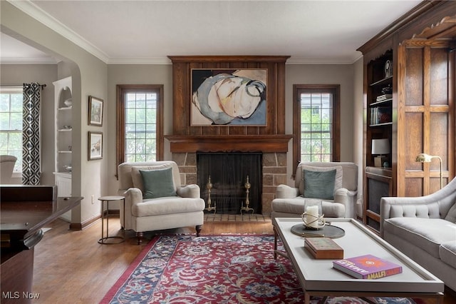 living area with crown molding, plenty of natural light, and wood finished floors