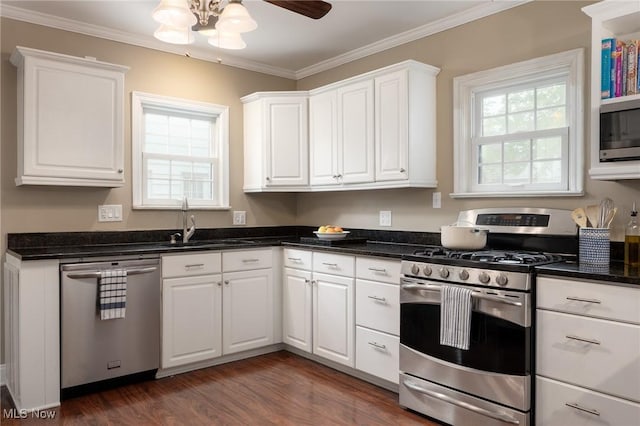 kitchen with white cabinets, dark wood-style flooring, crown molding, and appliances with stainless steel finishes