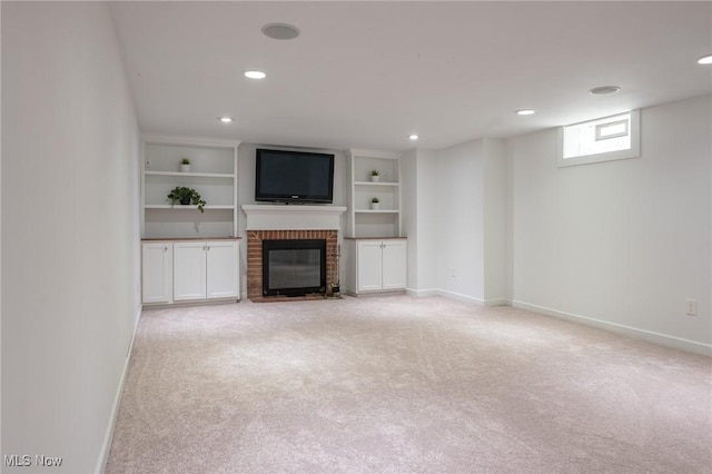 unfurnished living room featuring baseboards, a fireplace, recessed lighting, and light colored carpet