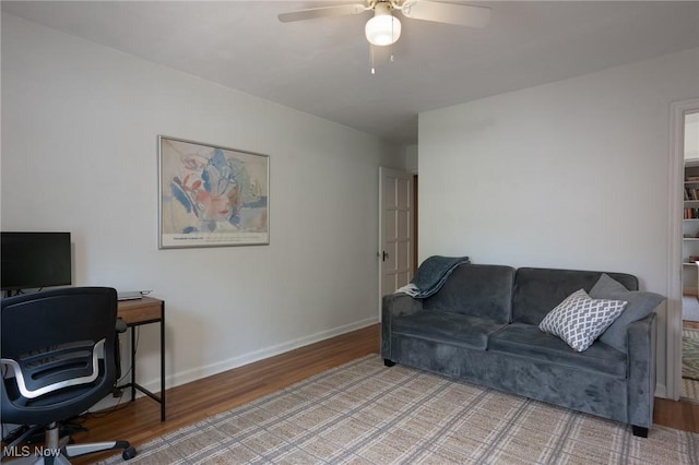 home office with baseboards, a ceiling fan, and light wood finished floors
