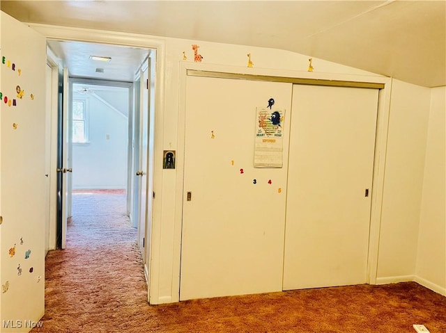 corridor featuring lofted ceiling and carpet