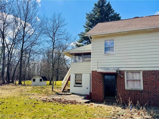 25911 Tryon Rd, Oakwood Village, OH 44146 - rear view of house featuring a shed, stairs, a lawn, an outbuilding, and brick siding