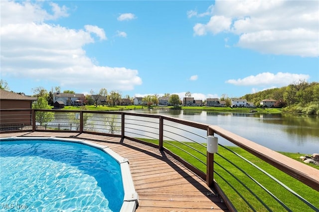 outdoor pool with a water view, a yard, and a residential view