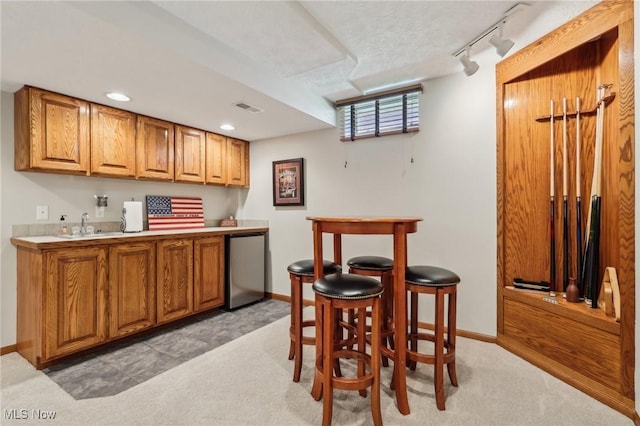 kitchen with visible vents, brown cabinets, and light colored carpet