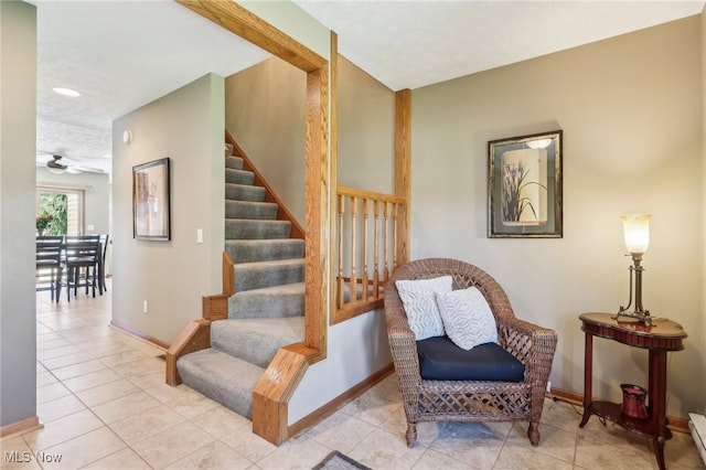 stairway featuring baseboards, ceiling fan, a baseboard heating unit, and tile patterned flooring