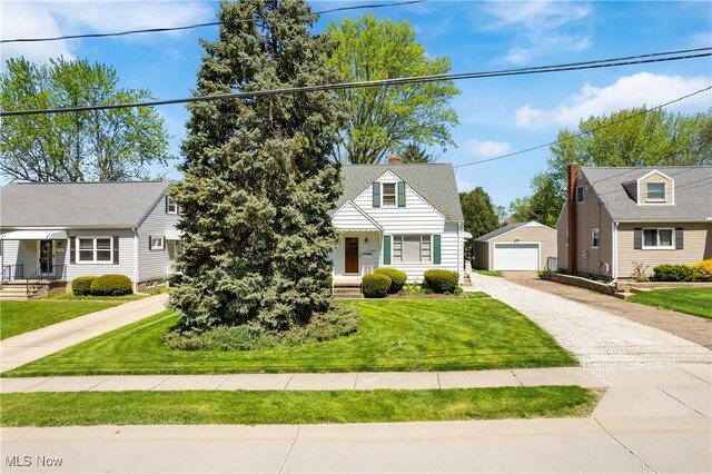 view of front of property with an outdoor structure, covered porch, a front yard, driveway, and a detached garage