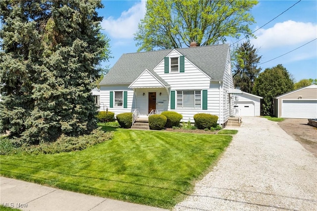 view of front of home featuring a front lawn, a detached garage, a porch, a chimney, and an outdoor structure