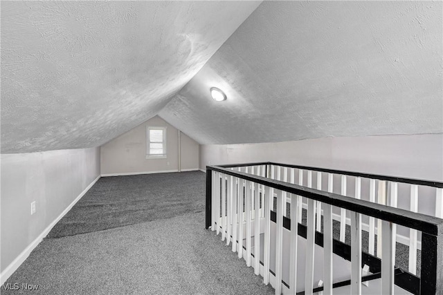 bonus room with a textured ceiling, baseboards, and lofted ceiling