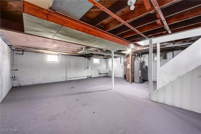 below grade area with a sink and gas water heater