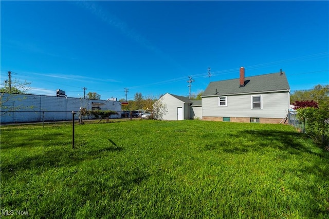 view of yard featuring fence and an outbuilding