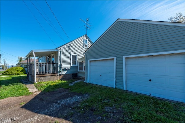 view of side of home with a garage and a porch