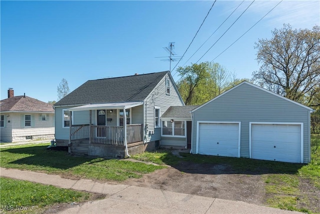 view of front of house featuring covered porch, a shingled roof, and a front yard