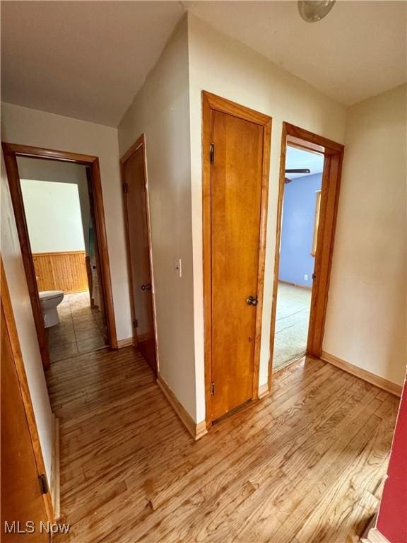 hallway featuring baseboards and light wood-style flooring