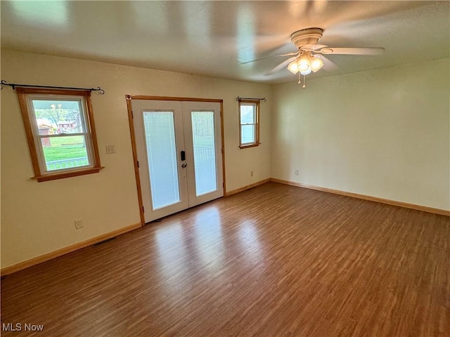spare room with french doors, baseboards, ceiling fan, and wood finished floors