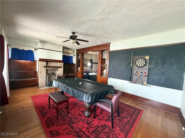 207 E Crown Ave, Pennsboro, WV 26415 - recreation room featuring billiards, a ceiling fan, a textured ceiling, a brick fireplace, and wood-type flooring