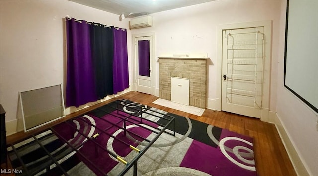 207 E Crown Ave, Pennsboro, WV 26415 - bedroom with a fireplace with flush hearth, baseboards, an AC wall unit, and wood finished floors