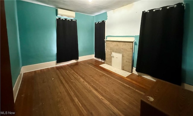 207 E Crown Ave, Pennsboro, WV 26415 - empty room featuring an AC wall unit, baseboards, and wood finished floors
