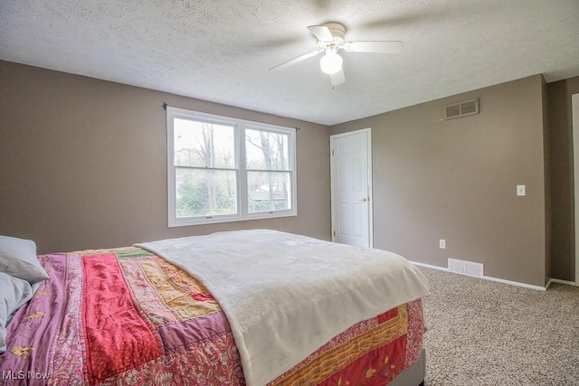 bedroom featuring carpet floors, a textured ceiling, visible vents, and baseboards
