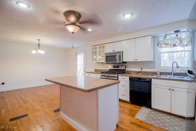 kitchen featuring a sink, stainless steel appliances, light wood-style flooring, and white cabinetry