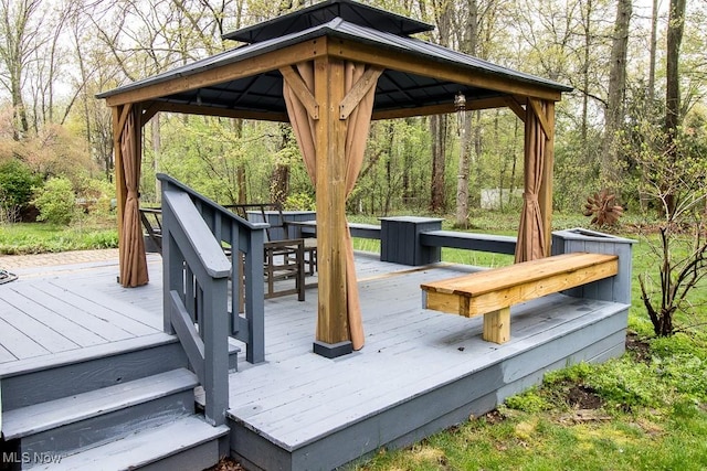 deck featuring a gazebo and a wooded view