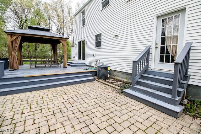 view of patio / terrace with entry steps, central AC unit, a gazebo, and a wooden deck