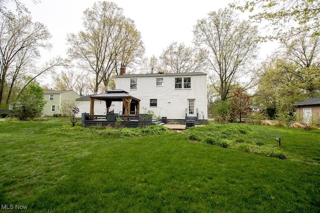 back of house with a gazebo, central AC unit, a lawn, and a chimney