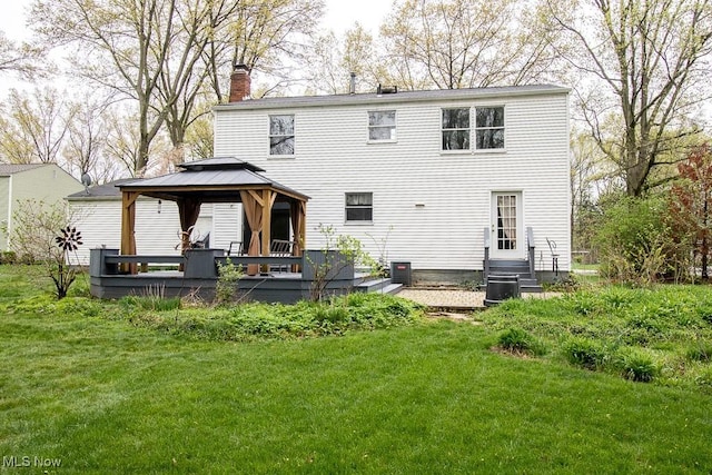 back of property with a lawn, a wooden deck, a chimney, a gazebo, and central air condition unit