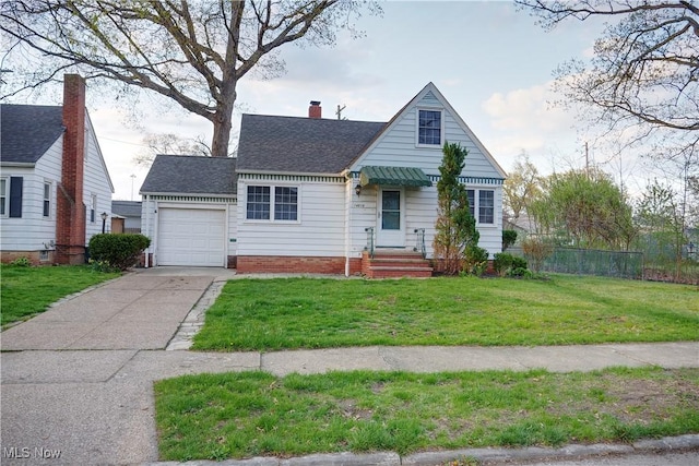 view of front of home with fence, a shingled roof, a garage, a front yard, and concrete driveway