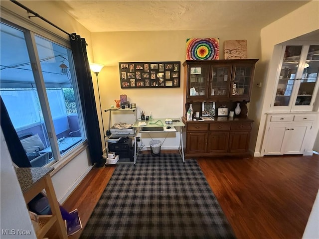 office space with baseboards and dark wood finished floors