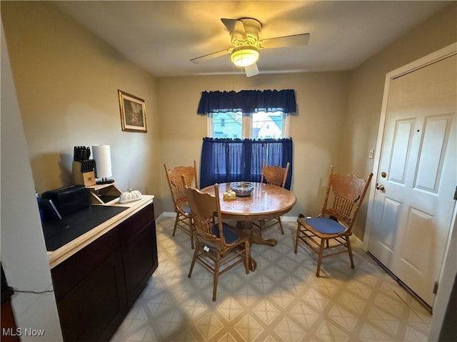 dining area with light floors, ceiling fan, and baseboards