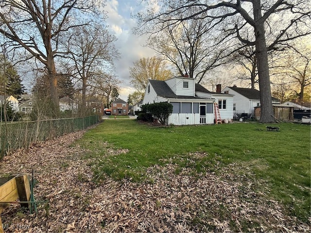 view of yard featuring a sunroom and fence
