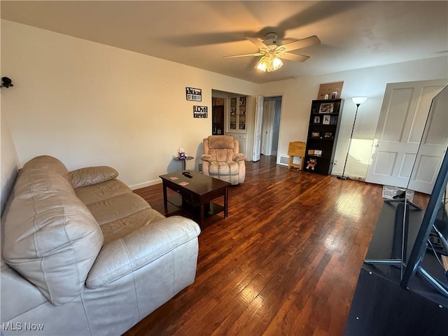living area with ceiling fan, baseboards, and hardwood / wood-style floors