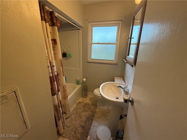 full bath with toilet, baseboards, tile patterned floors, a sink, and shower / tub combo