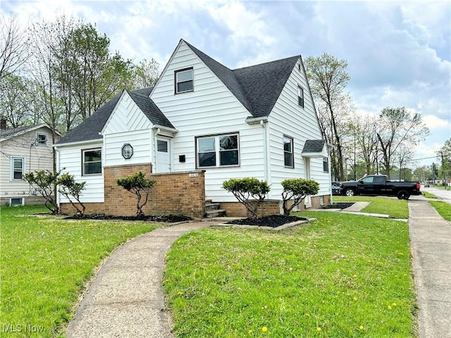 bungalow-style home with roof with shingles and a front lawn