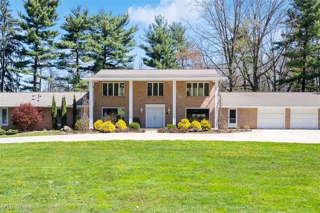 view of front of home with brick siding, a garage, driveway, and a front yard