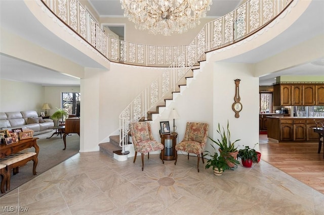 foyer entrance featuring stairs, a high ceiling, and a notable chandelier