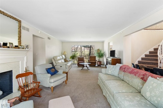 living room with carpet floors, ornamental molding, stairs, visible vents, and a fireplace