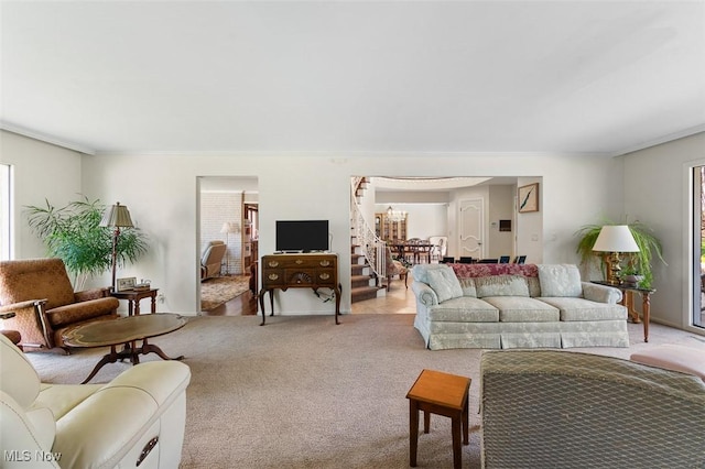 living room with crown molding and light colored carpet
