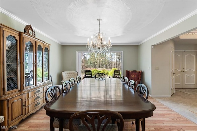 dining area featuring baseboards, ornamental molding, a tray ceiling, and a chandelier