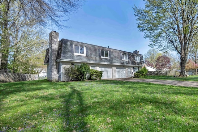 view of front of property featuring mansard roof, fence, a chimney, and a front yard