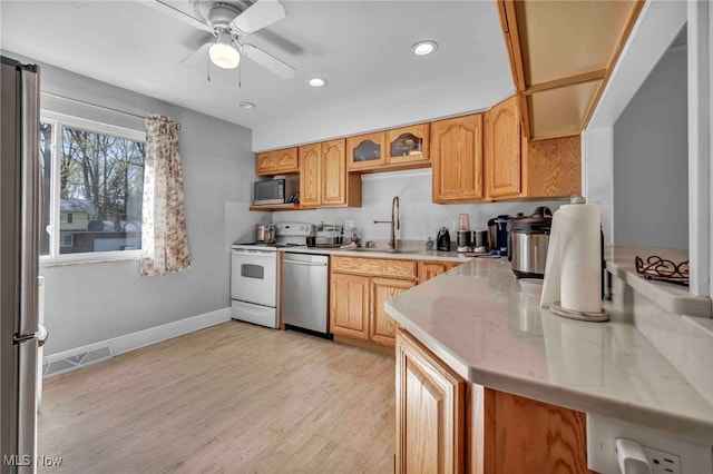kitchen with a ceiling fan, visible vents, appliances with stainless steel finishes, a sink, and light wood finished floors